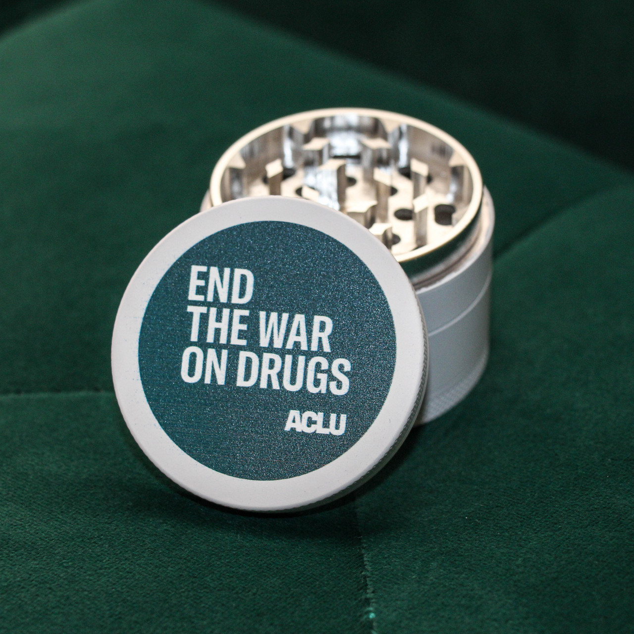 green and white herb grinder that reads end the war on drugs
