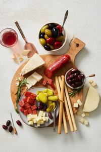 Assorted charcuterie board items arranged on a wood board Assorted charcuterie board items arranged on a wood board